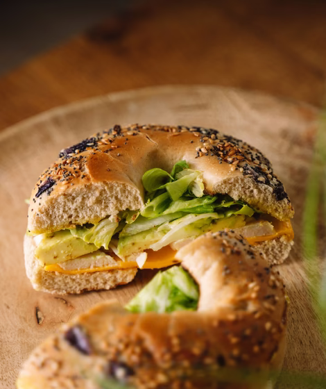 Belegte Brote © unsplash.com / Erwan NONON Belegtes Sesam Bagel mit Avocado, Blattspinat, Käse und Sauce