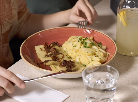 Detailaufnahme Maultaschen mit Kartoffelsalat, einem Glas Wasser & Limonade